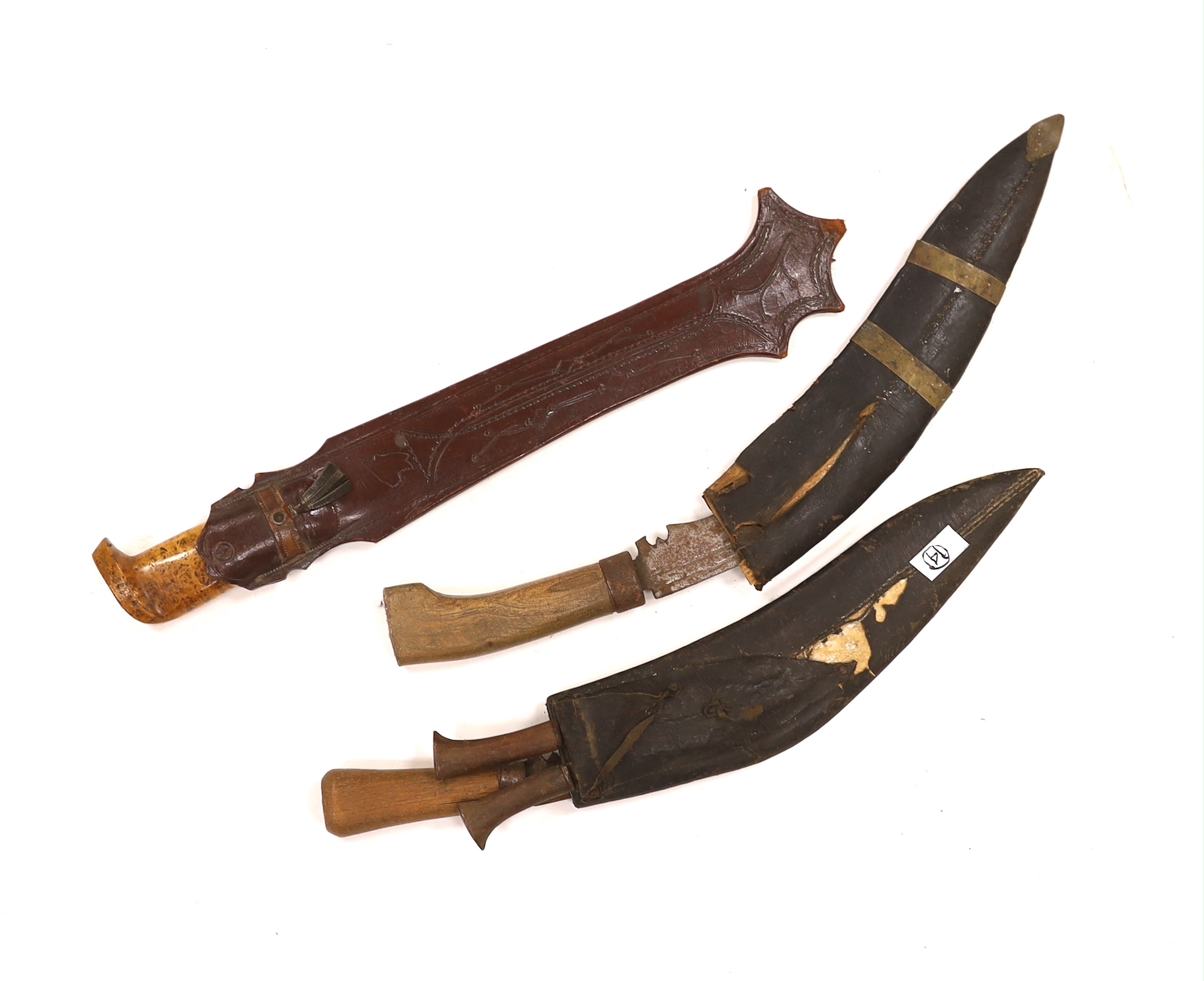 A large Finnish hunting knife, blade dated 1940 and burr wooden handle in its leather sheath, and two Indian kukri in their sheaths